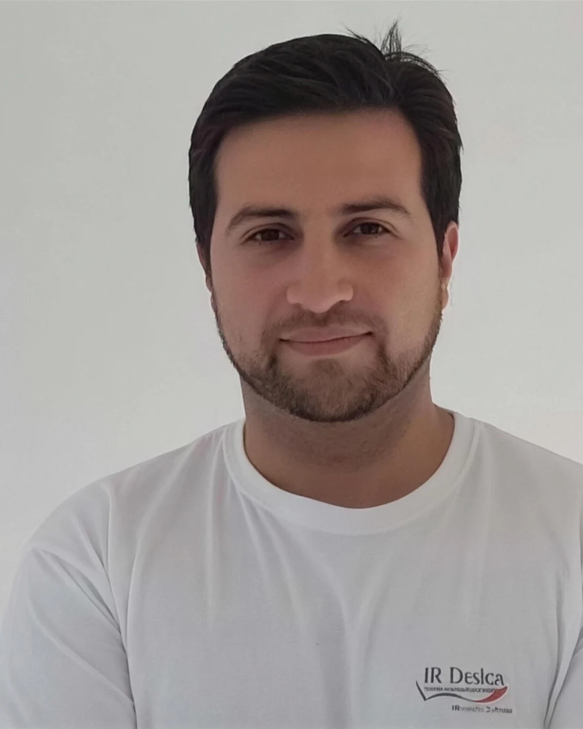 Malermeister Ibrahim Özdemir im weißen Arbeitsshirt vor einer hellen Wand