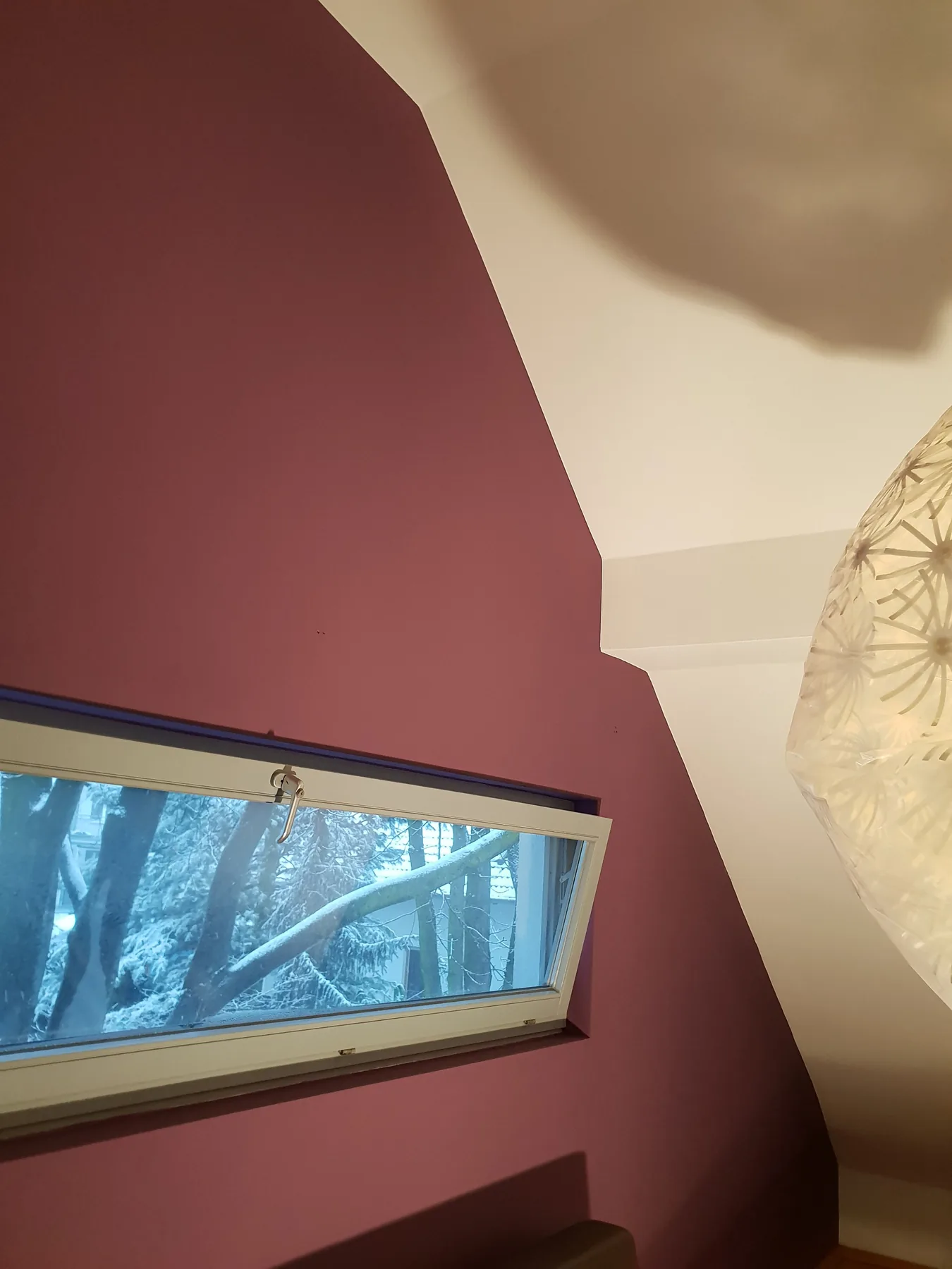 Detail der rostroten Dachschräge mit Fensterband und Deckenleuchte