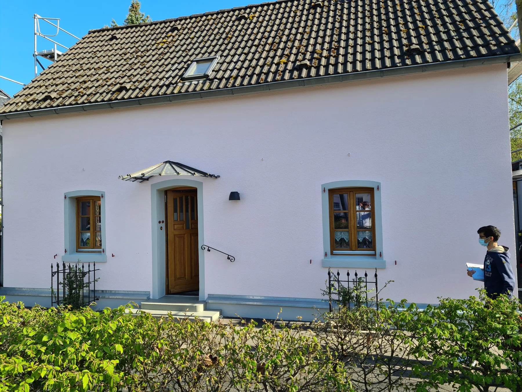 Frisch gestrichenes Einfamilienhaus in Rosé mit hellblau abgesetzten Fensterfaschen