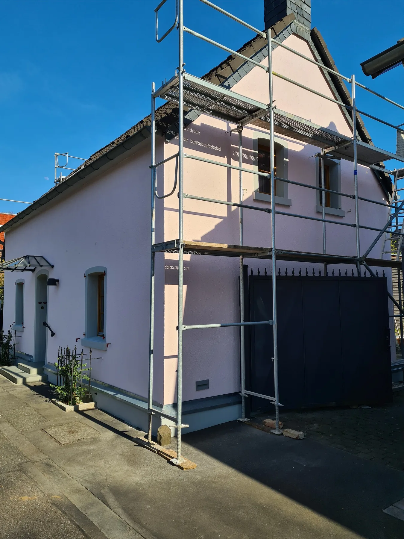 Giebelseite eines Hauses im Gerüst, Fassade in Rosé